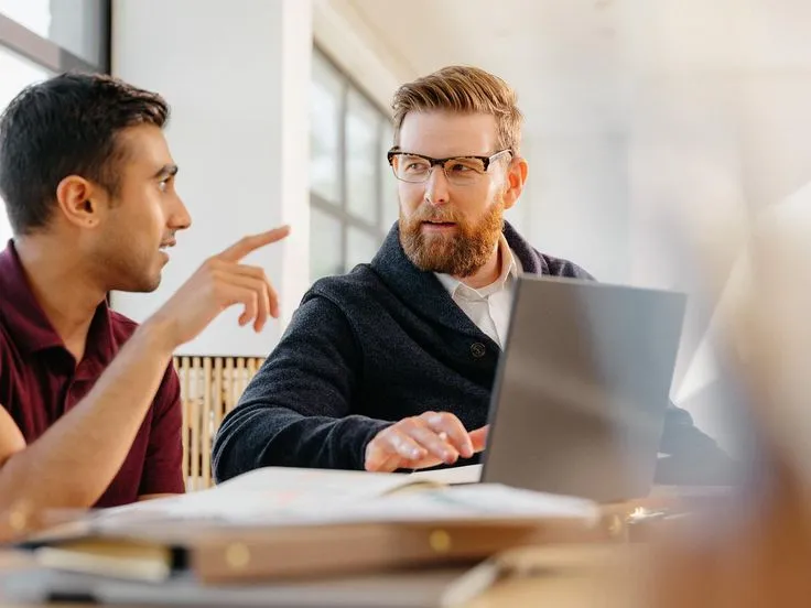 Zespół omawia dashboardy i trendy danych podczas spotkania decyzyjnego